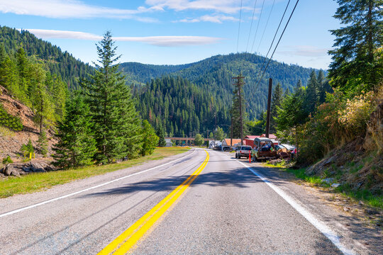 A rural highway leading to the historic town of Wallace, Idaho, once a major mining center in the North Idaho panhandle, now an EPA Superfund site due to contamination.