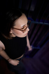 A stylish woman struts into the bar at night, exuding elegance and seduction of nightlife