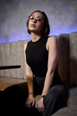 A stylish woman struts into the bar at night, exuding elegance and seduction of nightlife