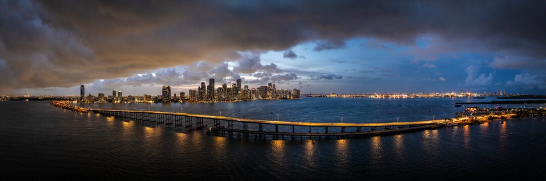 Aerial view of downtown miami skyline at dusk with rickenbacker causeway and illuminated high rise buildings, virginia key, usa.