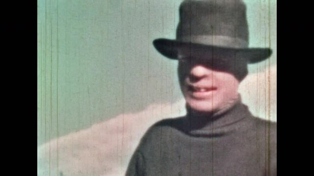 Portrait scary male character smiling evil outdoor in black hat against blue sky. Close-Up, creepy threatening bad guy. Freddy Krueger evil Halloween face. Vintage color film. Retro 1960s archive