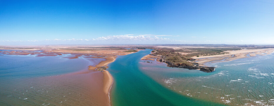 Aerial view of Nullagine River and Settlers Beach with beautiful sandy coastline and ocean waves, Cossack, Australia.