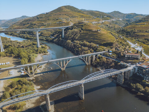 Aerial view of beautiful vineyards and bridges over a scenic river in a lush valley, Peso da Regua, Portugal.