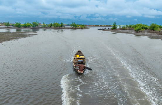 Aerial view of serene bodo river with fishing boats and lush green mangroves, Bonny, Nigeria.