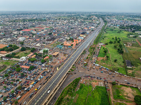 Aerial view of a bustling urban landscape with a flyover, busy roads, and greenery, Kaduna North, Nigeria.