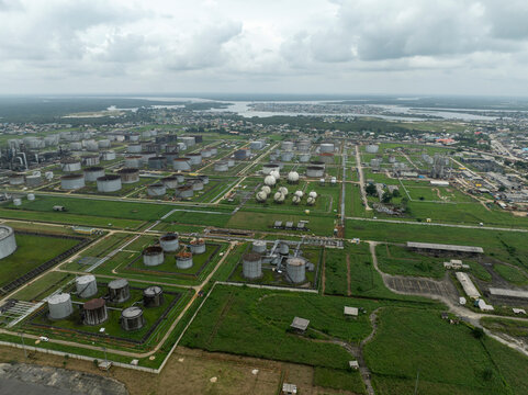 Aerial view of an industrial refinery complex with oil tanks and urban infrastructure, Eleme, Nigeria.