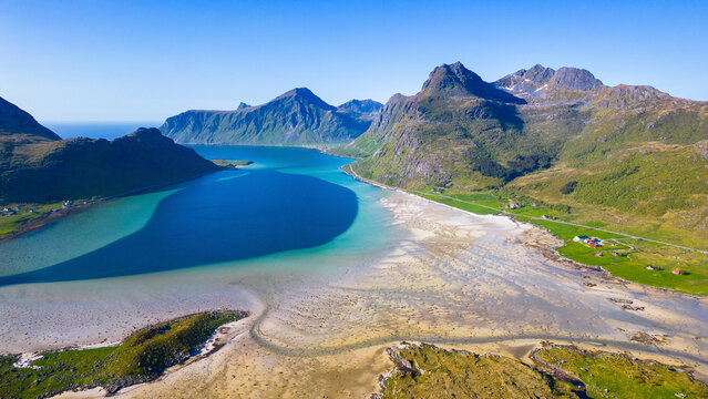 Aerial view of morpheus beach and fjord surrounded by majestic mountains and pristine water, Flakstad, Norway.