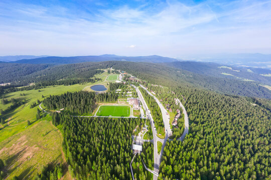 Aerial view of a beautiful forest and mountain resort with roads and buildings in a serene valley, Pohorje, Slovenia.