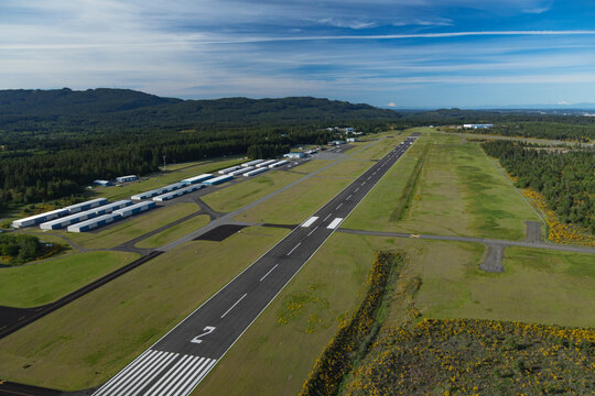 Aerial view of Bremerton National Airport with runway and hangars surrounded by serene greenery and forest, Bremerton, Washington, United States.