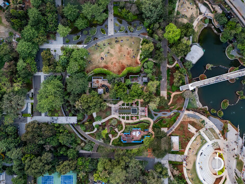 Aerial view of a beautiful park with a playground, pond, and bridge surrounded by greenery and trees, Thane, India.