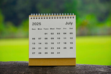 July 2025 white calendar with green blurred background - New year concept