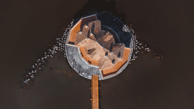 Aerial view of fusaro lake with casina vanvitelliana and scenic bridge, bacoli, italy.