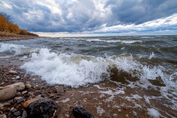 Obraz premium The ocean is rough and choppy, with waves crashing against the shore
