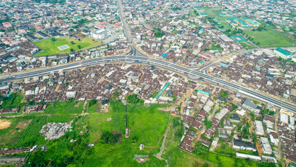 Aerial view of overpass construction amidst vibrant cityscape and greenery, Port Harcourt, Nigeria.