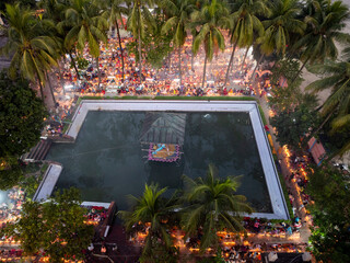 Aerial view of a vibrant evening festival with a luxurious pool surrounded by palm trees and decorative lights, Baradi, Sonargaon, Bangladesh.
