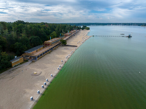 Aerial view of serene strandbad wannsee public beach with sandy shores and tranquil water, Nikolassee, Germany.