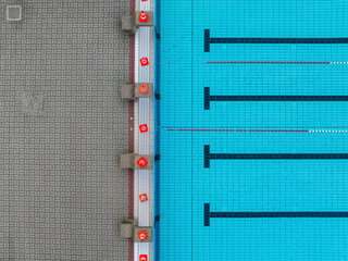 Aerial view of a tranquil public swimming pool with organized blue tiles and geometric patterns, Mariendorf, Germany.