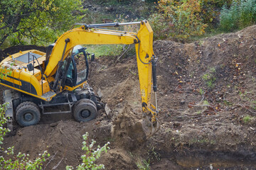 Excavator digging a pit with a bucket, excavator scooping soil with a bucket, excavator bucket working on a construction site