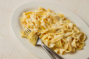 Fettuccine, tagliatelle, in creamy garlic sauce, Italian traditional cuisine, pasta carbonaro,