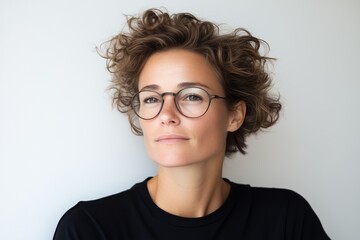 Obraz premium Portrait of a young woman with curly hair and eyeglasses looking confident and determined