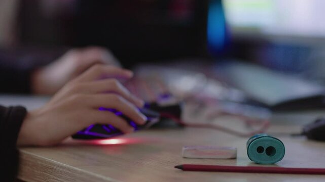 A 13-year-old intensely playing video games while school supplies like pencils and a sharpener are in focus, highlighting the issue of gaming addiction in students.