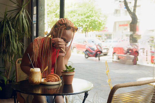 Young African woman can't eat because she is laughing so hard