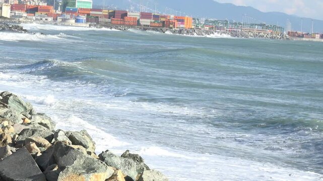 Coastal Port with Waves and Shipping Containers Under Mountains near Genoa Voltri