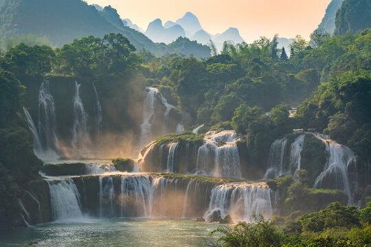 View of ban gioc detian falls surrounded by lush forest and majestic mountains, Huyen Trung Khanh, People's Republic of China.