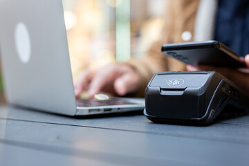 Customer paying with nfc technology on pos terminal in store