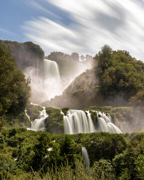 View of breathtaking Marmore waterfall surrounded by lush forest and rocks, Terni, Italy.