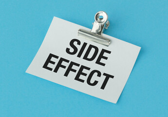 A clip holds a piece of paper that says Side Effect