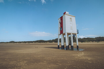 View of burnham on sea low lighthouse by the tranquil beach under a blue sky, burnham-on-Sea, England.