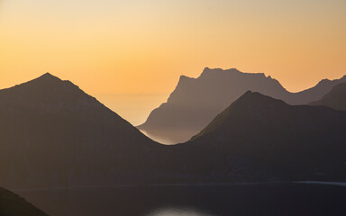 View of breathtaking mountains and ocean under the midnight sun at sunset, Leknes, Norway.