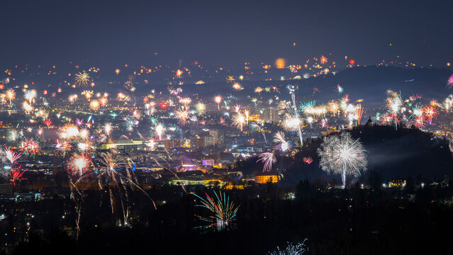View of vibrant fireworks display over the city skyline during New Year's Eve celebration, Graz, Austria.