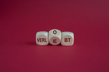 Turned a dice and changes the German expression 'verliebt' (in love) to 'verlobt' (engaged). Beautiful red background. Business concept.