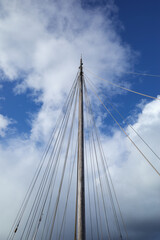 Fototapeta premium The mast without sails goes into the blue sky.