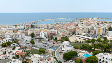 Aerial view of houses and buildings in Vieste, Puglia, Italy. In background is the Mediterranean Sea.