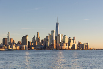 Obraz premium New York City skyline illuminated by the sunset over the river.
