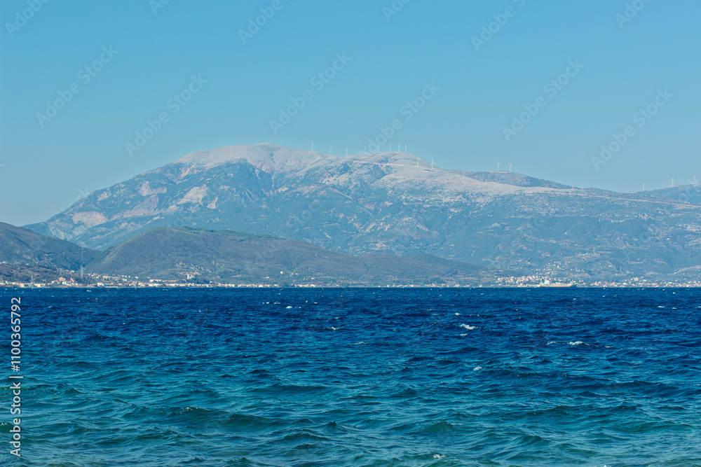 Wall mural sea scape wavy water panorama landscape with mountain range in mist background view