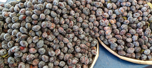 Bistritene plums exposed for sale at the fairFresh plums on a bazaar as a background