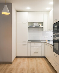 Modern kitchen interior. White corner kitchen in new apartment. 