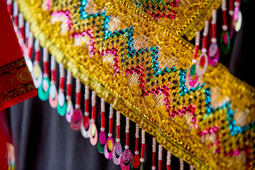 Close-up of Traditional Hmong Red Embroidered Costume with Lace Details – Intricate Ethnic Textile Design, Ideal for Vietnam Cultural and Heritage Themes.