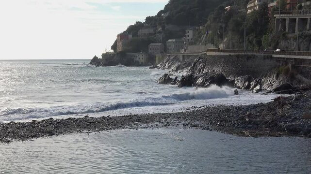 Waves crashing against the rocky cliffs of the coast on a sunny day, along the Via Aurelia from Genoa Voltri towards Vesima