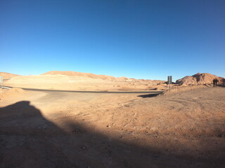 Vista ampla do Deserto do Atacama no Chile captada com uma GoPro, destacando paisagens áridas, terreno arenoso e montanhas ao longe sob um céu ensolarado