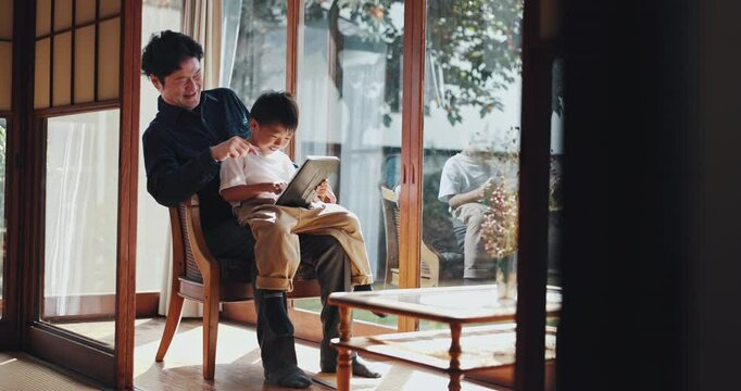 Japanese, child and dad on tablet in house with game, family and education app with video. Online, website and youth development with love, care and support in living room with tech and help