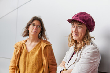 Sucessful businesswoman with empowered expression while her colleague is looking at her with envy