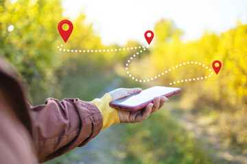 Close-up of hikers using a GPS navigation app on a smartphone to find their route in the forest....