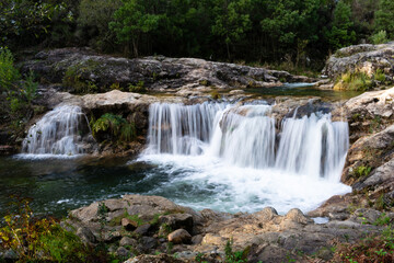 Fototapeta premium Scenic view of waterfall on rock formation in forest in Loureza - Spain