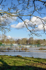 River burst it's banks in northamptonshire uk causing flooding the flood water covers local amenities and parkland