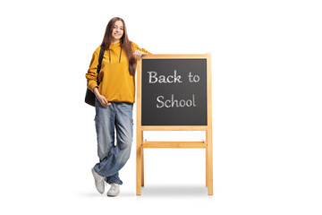 Teenage student leaning on a blackboard with text back to school © Ljupco Smokovski